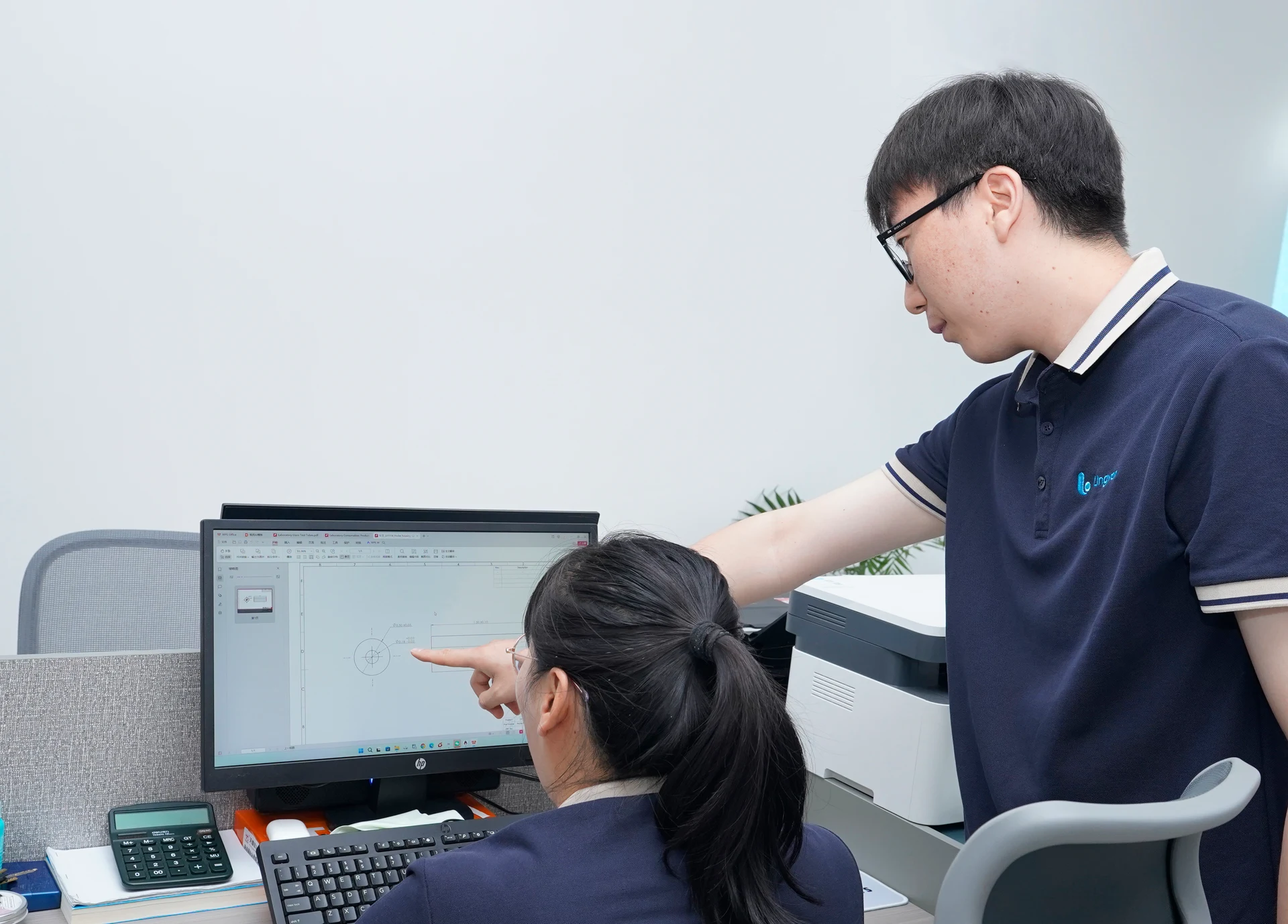 Staff reviewing information on a computer and discussing product and technical details.
